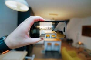 A smartphone in focus capturing a modern kitchen interior, showcasing real estate potential.